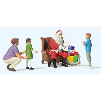 Weihnachtsmann im Sessel, Mutter mit Kindern und Geschenkpaketen