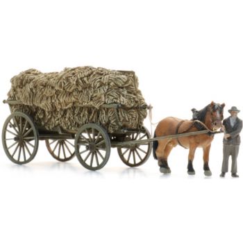 Pferdegespann mit Leiterwagen beladen mit Heu und Bauer bei der Heuernte