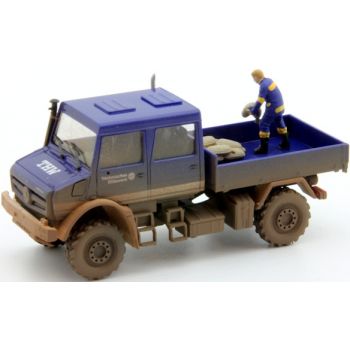 MB Unimog U5023 Doppelkabine Pritsche, THW Technisches Hilfswerk Hochwasserschutz mit Figur, die Sandsäcke von der Ladefläche hebt, mit Schlammspitzer