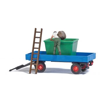 Traubenernte mit Gummiwagen, Anhänger mit Leiter und Behälter für Trauben sowie einem Helfer für die Weinlese mit Bütte auf dem Rücken.