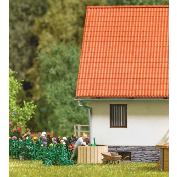 Wasser holen: Frau, die mit einer Gießkanne Wasser aus dem Regenfass schöpft. Mit div. Zubehör