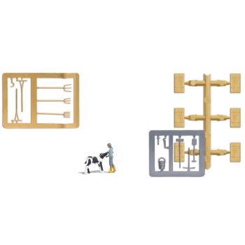 Kälberfütterung, Bäuerin, die eine Kuh mit der Milchflasche füttert. Mit Heuballen und Stallwerkzeug