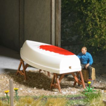 Boot streichen, Maler, der ein Boot neu anstreicht, mit Motorboot, Reparaturböcken, Werkzeugkiste und Farbeimer