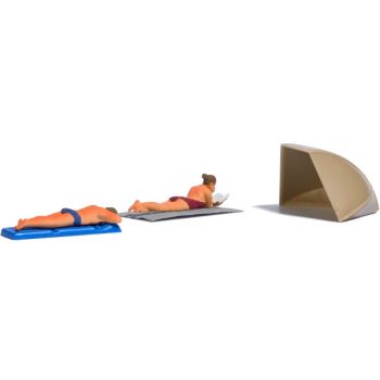 Sonnenbrand - ein Paar liegt schon viel zu lange inder Sonne, Luftmatratze, Liegetuch und Strandmuschel