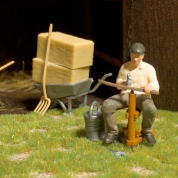 Sense dengeln, die Sense wird beim Dengeln geschärft, Set enthält Figur mit Dengelhammer, Sense, Dengelpflock, Heuballen, Schubkarren und Werkzeug